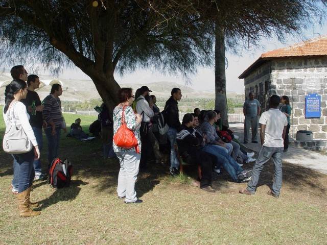 קבוצה נהנת בדשא הירוק תחת צל